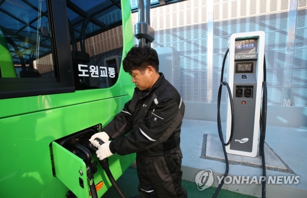 서울 성북구 정릉 도원교통 차고지에서 한 직원이 서울 시내버스에 처음으로 도입된 1711번 전기버스에 충전을 하고 있다. [사진=연합뉴스]