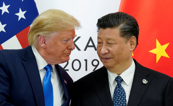 도널드 트럼프(왼쪽) 미국 대통령과 시진핑 중국 국가주석이 지난 6월 일본 오사카에서 열린 미중 정상회담에 묘한 미소를 띤 채 마주보고 있다. [사진 연합뉴스]