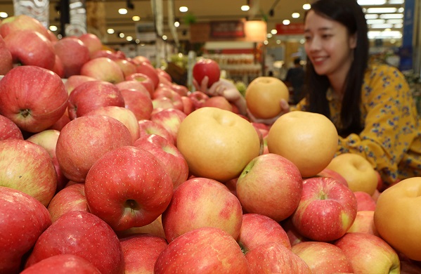 19일 오전, 롯데마트 서울역점에서 고객이 '다다익선' 행사장에서 사과와 배를 보는 모습.
