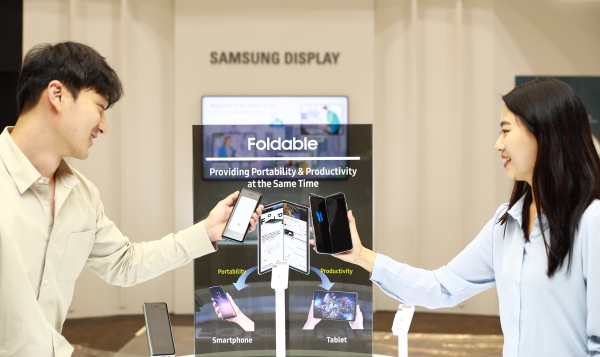 삼성디스플레이 직원들이 'IMID 2019'에서 폴더블 디스플레이를 채용한 '갤럭시 폴드'를 체험하고 있다. [삼성디스플레이 제공]