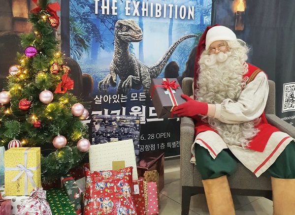 크리스마스를 하루 앞둔 24일, 롯데백화점 김포공항점에서 핀란드 공식 산타가 아이들에게 선물을 나눠주고 기념촬영을 하고 있다.