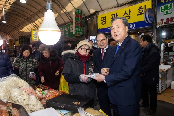 박차훈 새마을금고중앙회장(사진 오른쪽)이 전통시장에서 온누리상품권으로 물건을 구매하고 있다. [사진=새마을금고중앙회 제공]