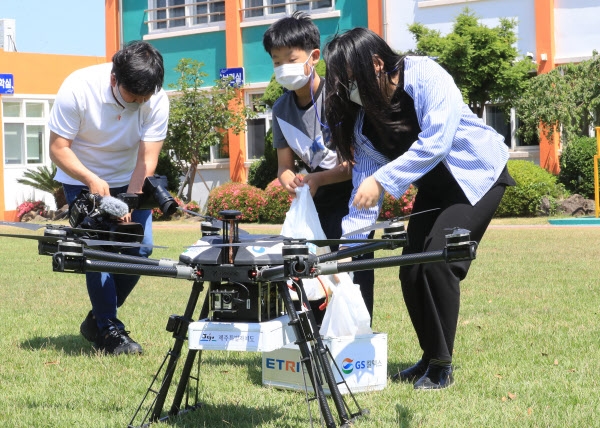 8일 오전 해안초등학교 학생들이 0.8㎞를 날아 간식을 배달한 드론을 반기고 있다