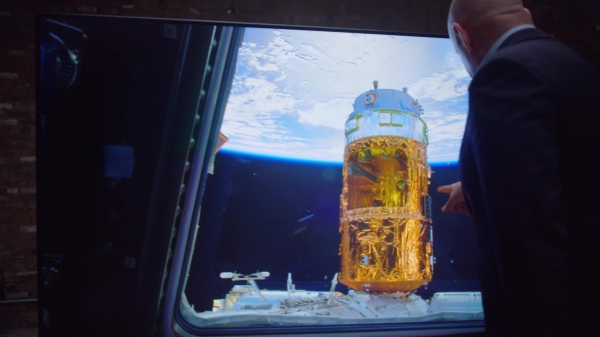 영상 속의 한 장면으로 스콧 켈리가 우주에서 촬영한 지구의 모습을 삼성전자 QLED 8K TV로 감상하고 있다. [사진=삼성전자]