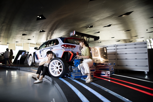 현대 모터스튜디오 고양 2층 ‘N 체험존’에서 고객들이 ‘i30 N TCR’로 실제 모터스포츠 경기장에서 이뤄지는 마모 타이어 교체 체험을 하고 있는 모습. [사진=현대자동차]