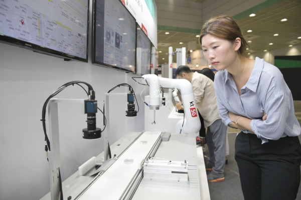 26일 열린 중소기업기술혁신대전에서 KT 부스를 방문한 관람객들이 5G 기반 협동로봇과 머신비전 등 전시물들을 둘러보고 있다. [KT 제공]
