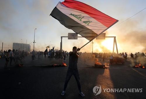 반정부 시위대가 이라크 국기를 흔들고 있다. [AFP=연합]